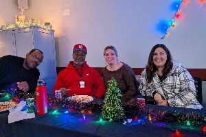 two men and two women sitting at a Christmas party table